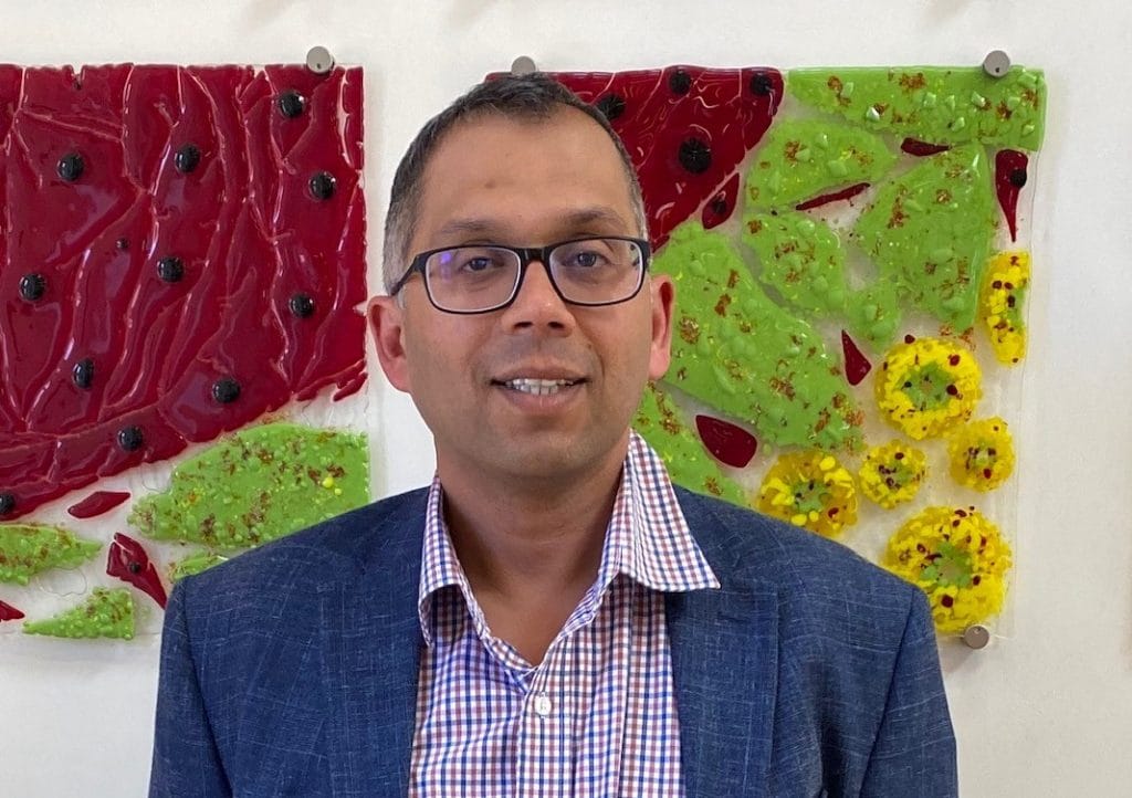 Portrait photo of Dr Dilip Nazareth against colourful background